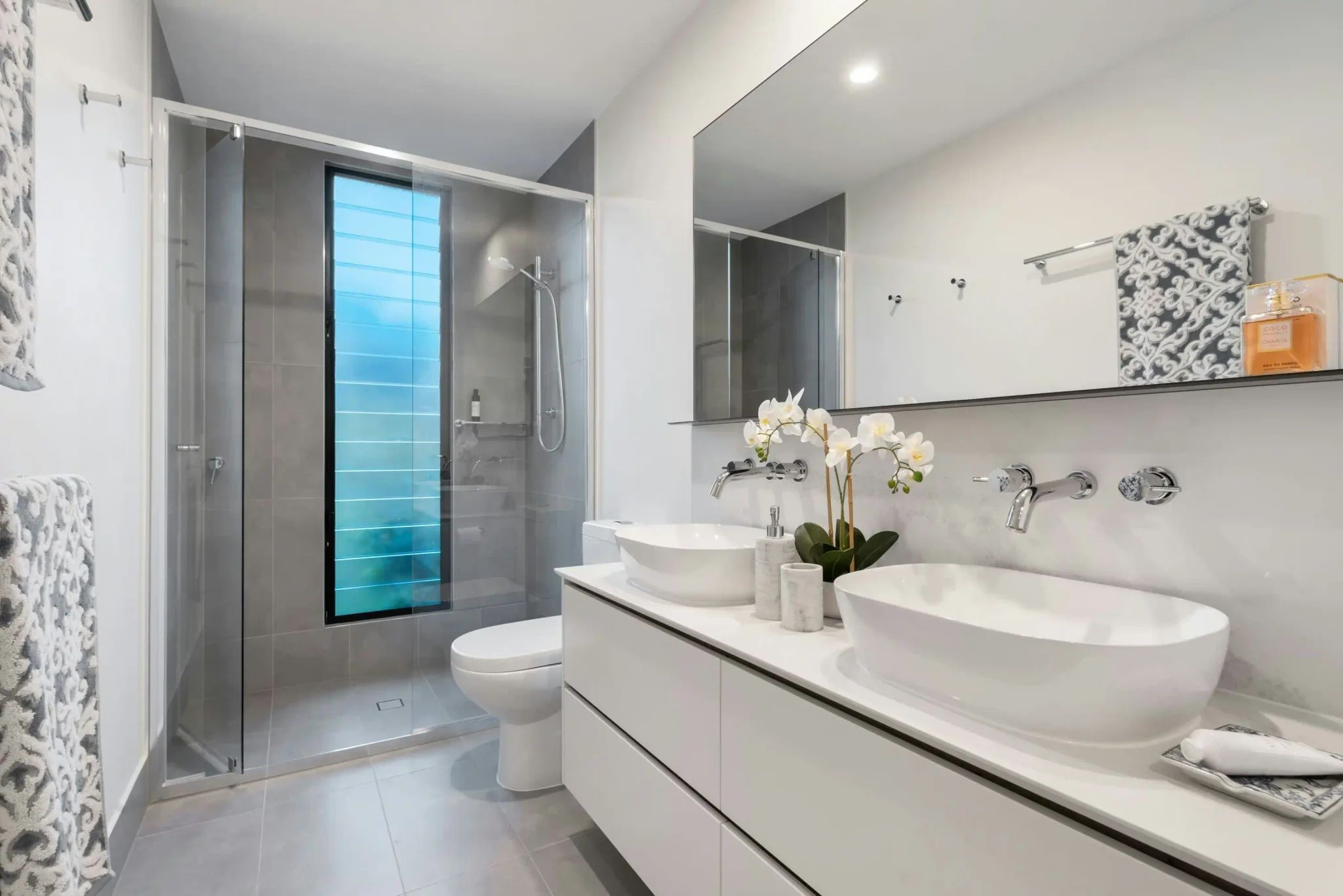 Modern bathroom with double vessel sinks and gray wall tile